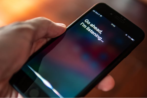 User holding a phone with a chat interface on the screen